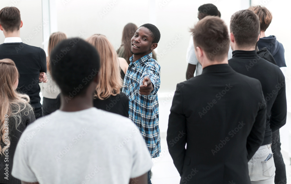 young man standing among a group of diverse young people young man standing among a group of diverse young people