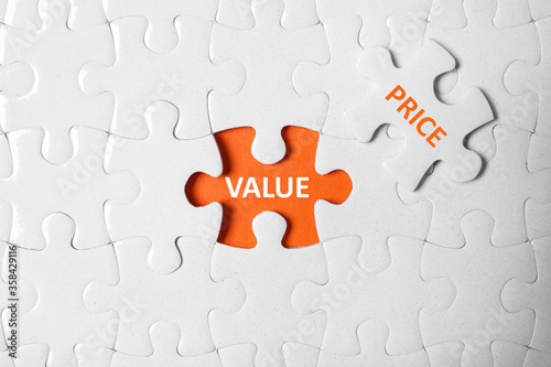 Puzzle with phrase PRICE VALUE on orange background, top view photo