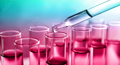 Dropping sample into test tube with liquid on color background, banner design. Laboratory analysis