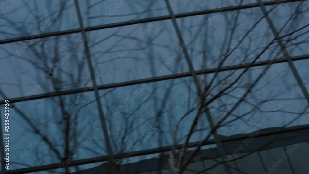 MONTREAL, CANADA - MARCH 14 2019 Angled pan tracking shot of glassy windows on an office skyscraper reflecting commercial buildings opposite. MONTREAL, CANADA - MARCH 14 2019 Angled pan tracking shot of glassy windows on an office skyscraper reflecting commercial buildings opposite.