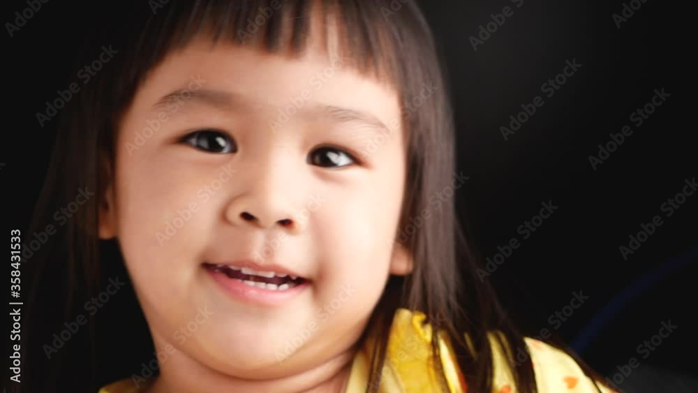 Portrait face of Asian little child girl with happy expression on dark background. Portrait face of Asian little child girl with happy expression on dark background.
