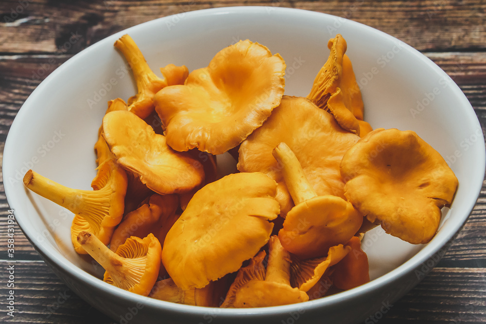 Forest orange chanterelle mushrooms on brown wooden background Forest orange chanterelle mushrooms on brown wooden background