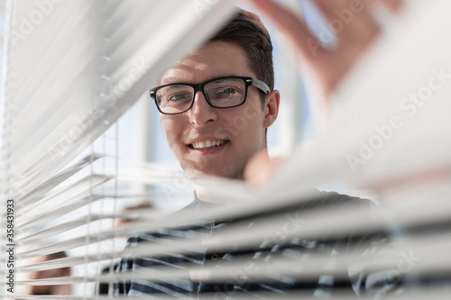 young pensive businessman looking out the window in office