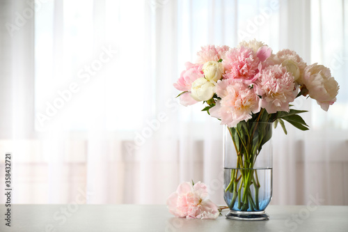 Beautiful peony bouquet in vase on table indoors. Space for text