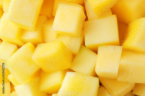 Many delicious mango cubes as background, closeup