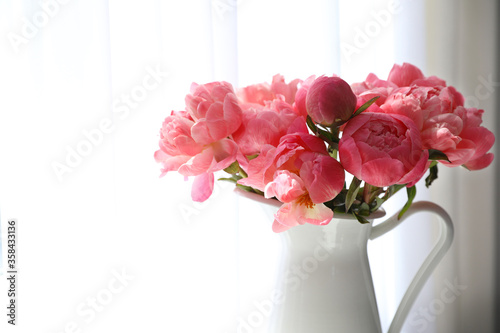 Fototapeta Naklejka Na Ścianę i Meble -  Beautiful bouquet of fragrant peonies in vase near window