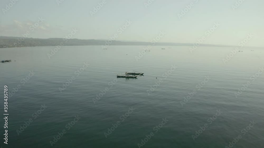 Aerial panning shot of boats on sea against sky, drone flying forward towards vessels - Wakatobi Regency, Indonesia Aerial panning shot of boats on sea against sky, drone flying forward towards vessels - Wakatobi Regency, Indonesia