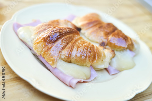 Fresh croissants with ham and cheese on plate