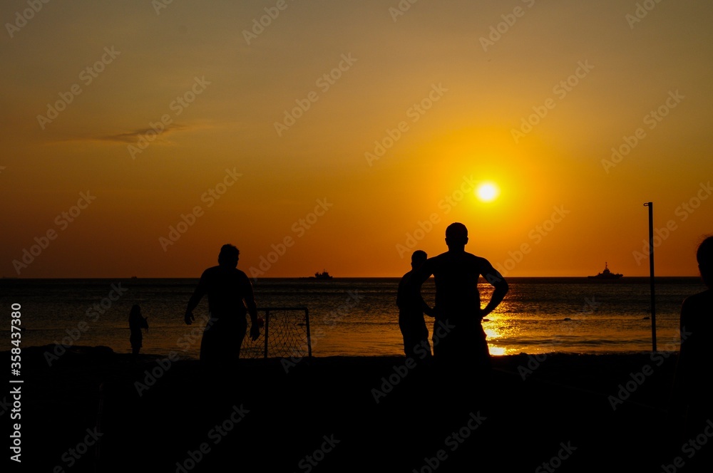 Amateurs playing football at Jumeira beach in Santa Marta, Colombia during sunset.
