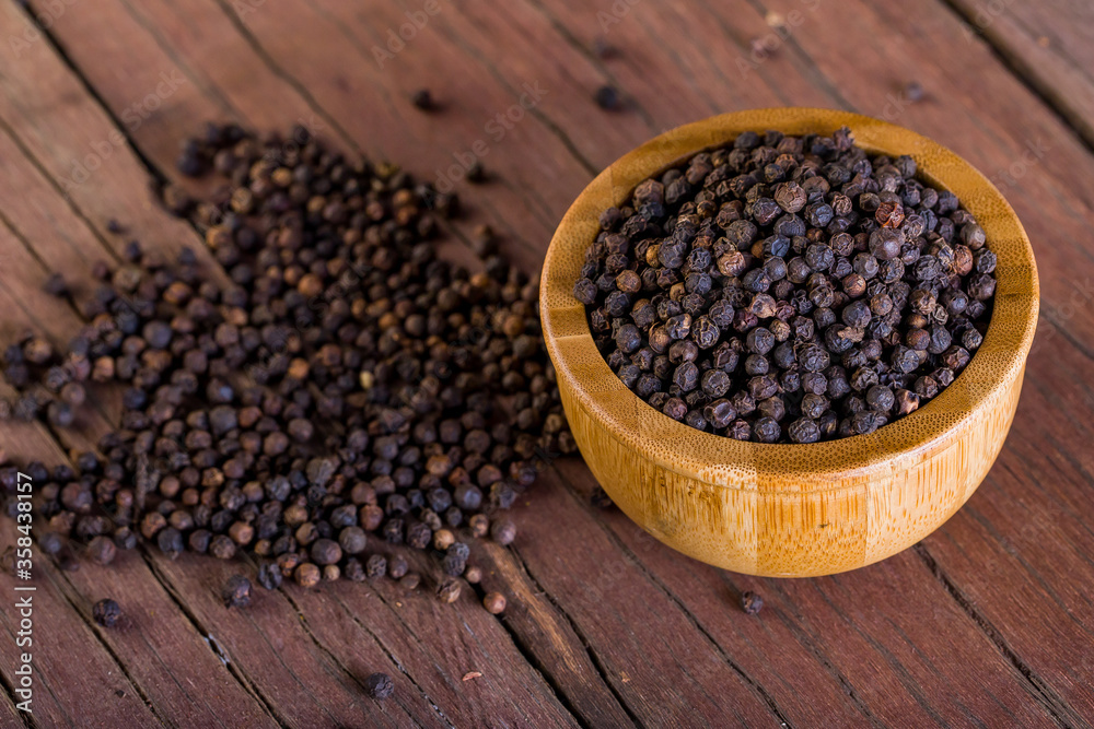 A lot of blackpeppers on wooden background. A lot of blackpeppers on wooden background.