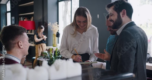 Happy young smiling gen-z business people casually sharing ideas, brainstorming at trendy loft light office coworking.