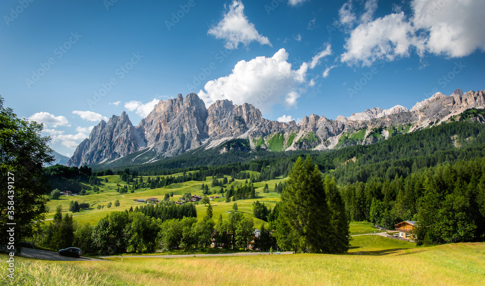 Mountains with alpine village on sunny summer day, the Dolomites Mountains, Italy