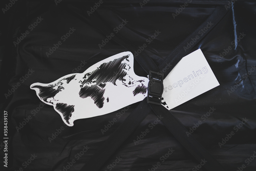 flying during covid19, carryon luggage with world map and reopening