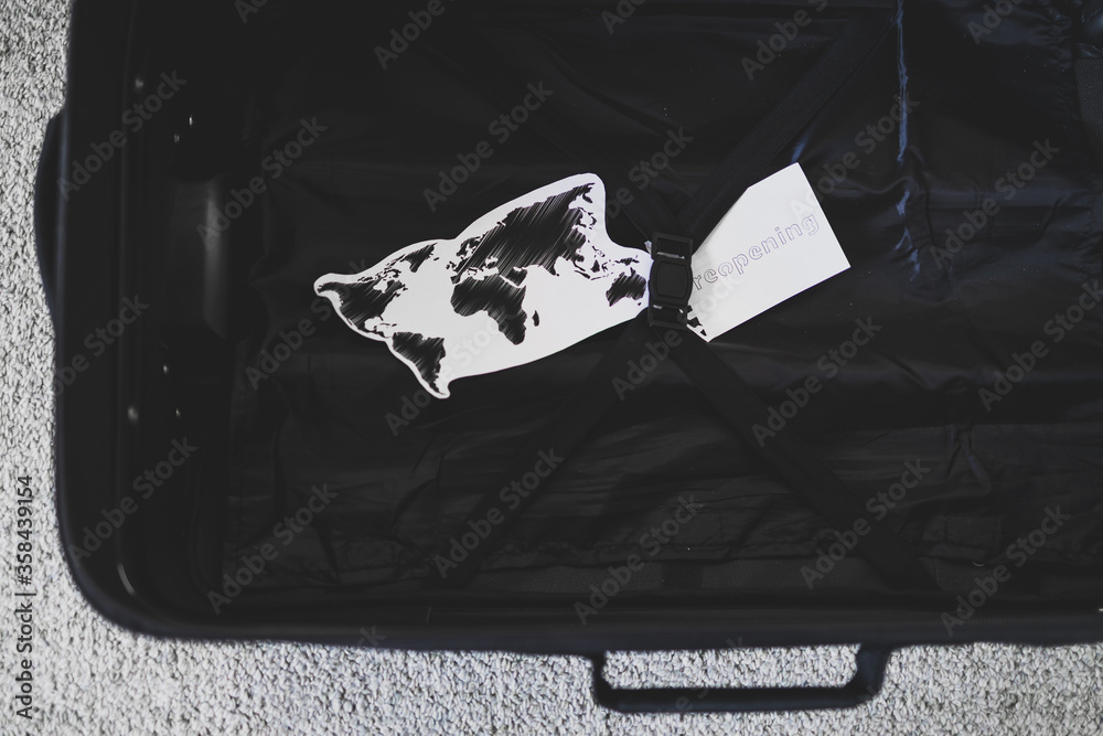 flying during covid19, carryon luggage with world map and reopening