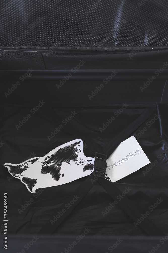 flying during covid19, carryon luggage with world map and reopening