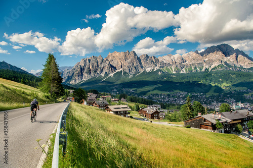 Mountains with alpine village on sunny summer day, the Dolomites Mountains, Italy 