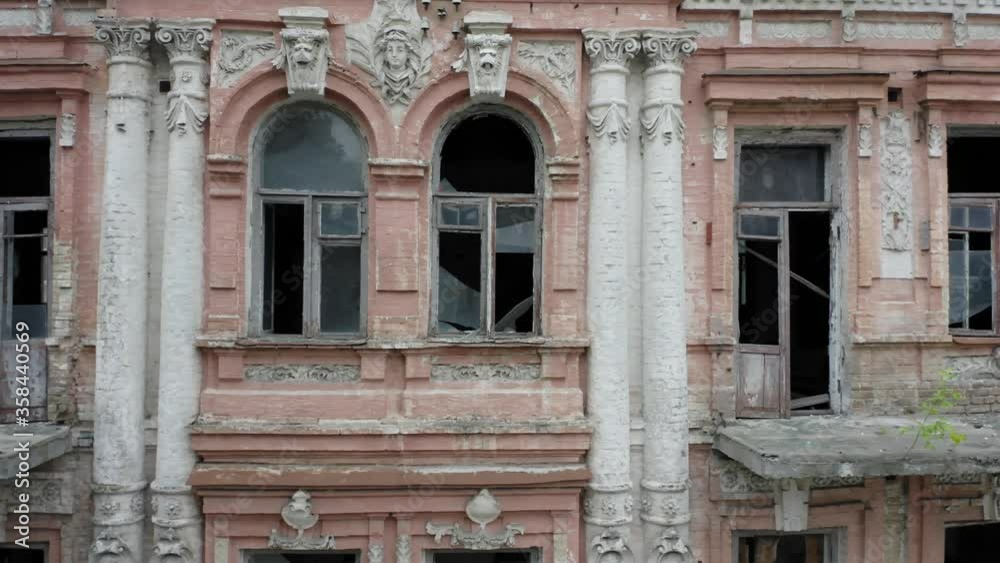 Abandoned old manor (mansion) house in the neoclassical style with an abundance of decor and broken windows. Deserted building of the 19th century. Aerial side view Abandoned old manor (mansion) house in the neoclassical style with an abundance of decor and broken windows. Deserted building of the 19th century. Aerial side view
