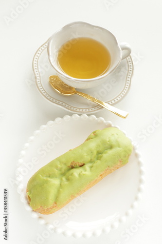 Green tea eclair puff cream confectionery on white dish with copy space