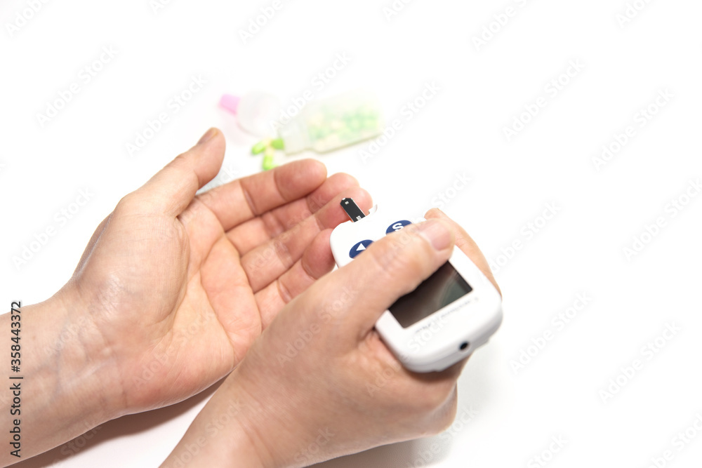A scene where blood is examined on a woman's finger using a glucose meter. A scene where blood is examined on a woman's finger using a glucose meter.