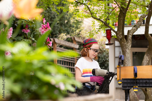 Young girl using nail gun