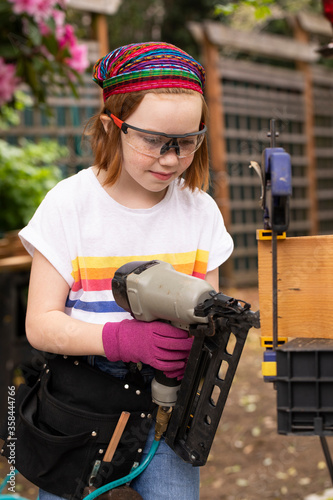 Young girl using nail gun