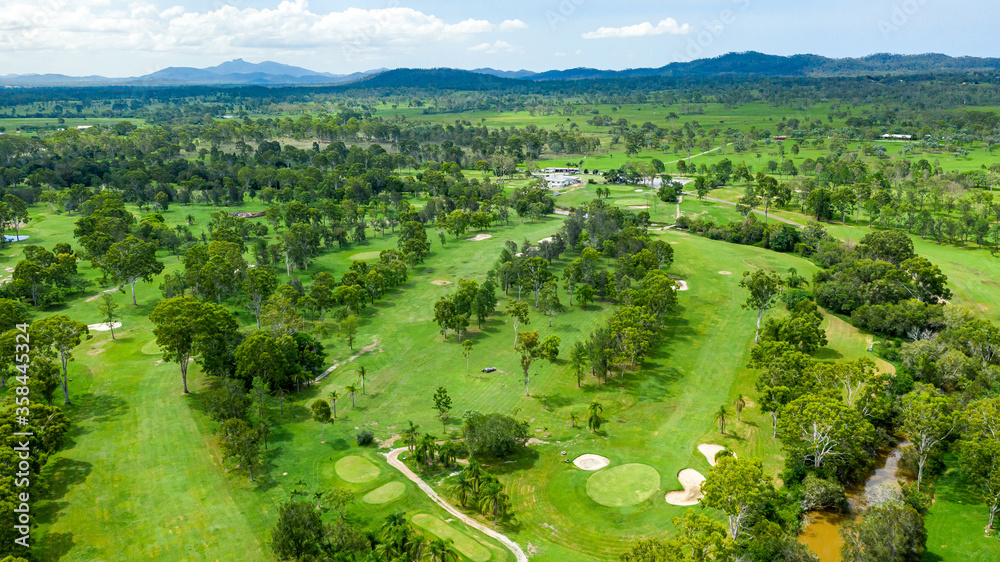 Vibrant green summer landscape showing a golf course and hills in the distance, in Calliope, Queensland