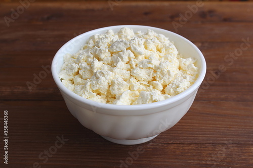 White plate with curd on a wooden table