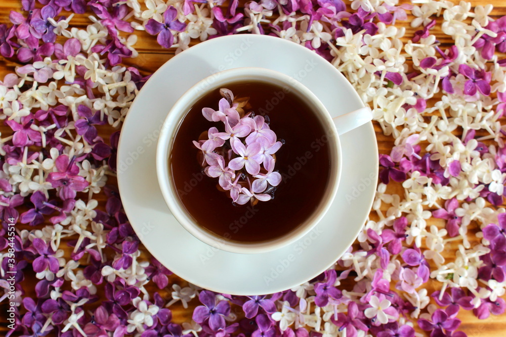 Cup of tea on a background of a wooden table and spring lilac Cup of tea on a background of a wooden table and spring lilac