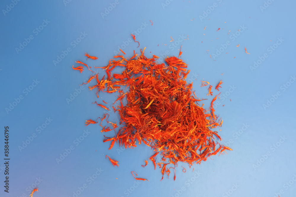 Naklejka premium sprinkled saffron on a blue background, Indian spices 