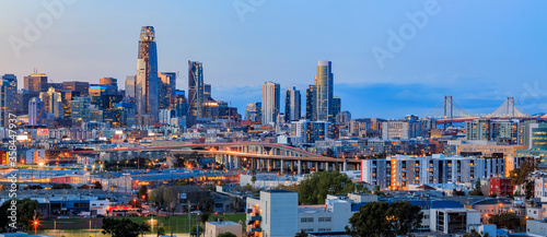 San Francisco city skyline panorama after sunset with city lights  the Bay Bridge and light trails leading into the city