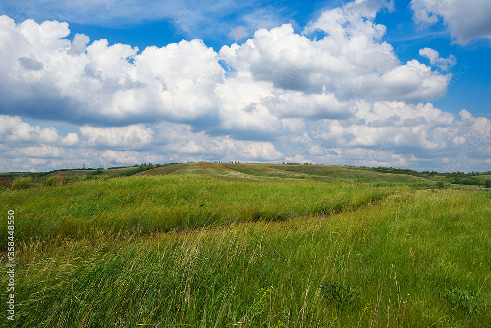 Summer natural landscape, meadow, field, hills. Beautiful blue sky with clouds. Summer natural landscape, meadow, field, hills. Beautiful blue sky with clouds.