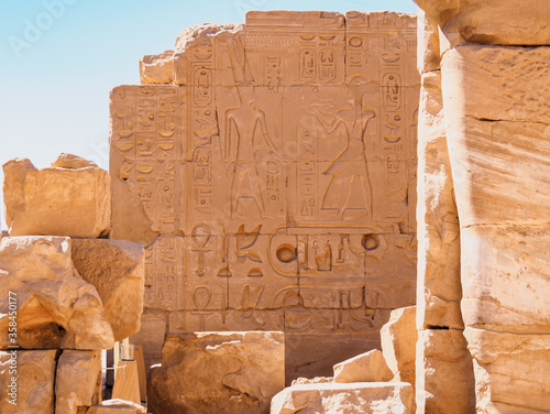 Egyptian legends painted on ruined brickwall, medium view. Ancient ruins of Karnak temple. Photographed in Luxor, Egypt. Selective soft focus. Blurred background