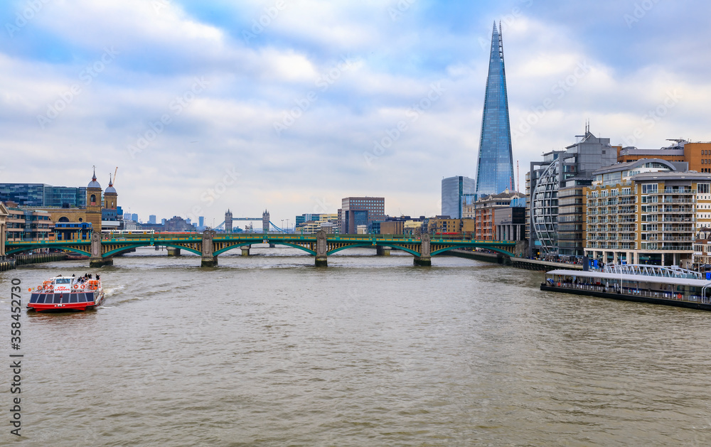 London, England skyline with the Shard, Southwark Bridge and Tower Bridge on Thames river during the day London, England skyline with the Shard, Southwark Bridge and Tower Bridge on Thames river during the day