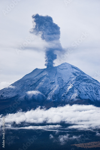 Popocatépetl cubierto de nueve expulsando fumarola