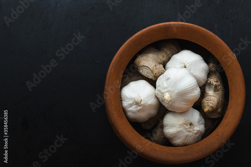Garlic and Ginger in clay pot on Black background