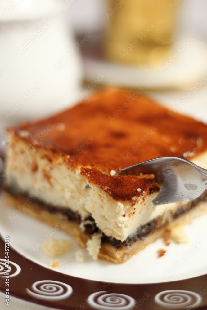 Eating cheesecake with poppy seed filling