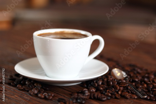 Cup of Coffee and Coffee Beans on wooden plank table