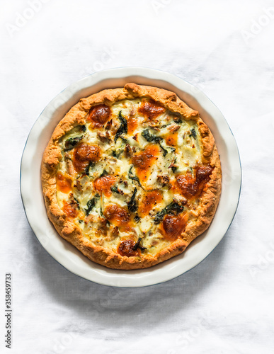 Tuna, mozzarella cheese, spinach, potatoes rustic simple pie on a light background, top view