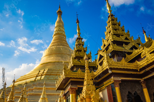 Buddhist Pilgrims in the Shwedagon Pagoda at night. It is the most sacred Buddhist pagoda for the Burmese. decoration image contain​ certain​ grain​ noise and​ soft​ focus.