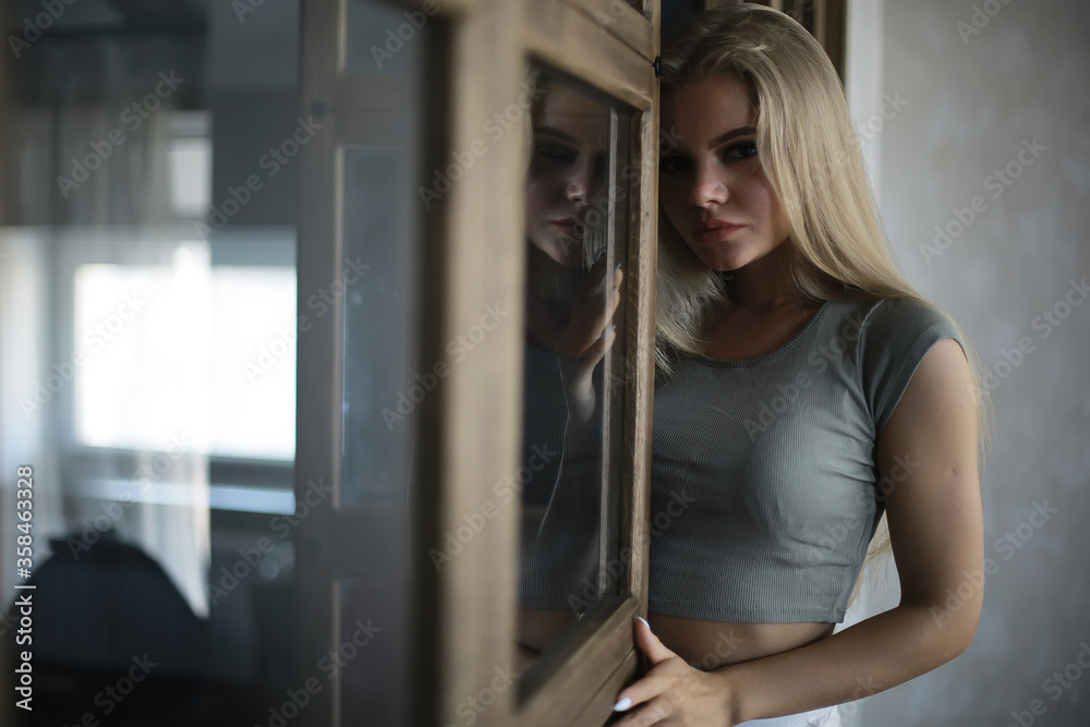 girl in a loft interior, modern house, windows, wall. young adult posing girl in a loft interior, modern house, windows, wall. young adult posing
