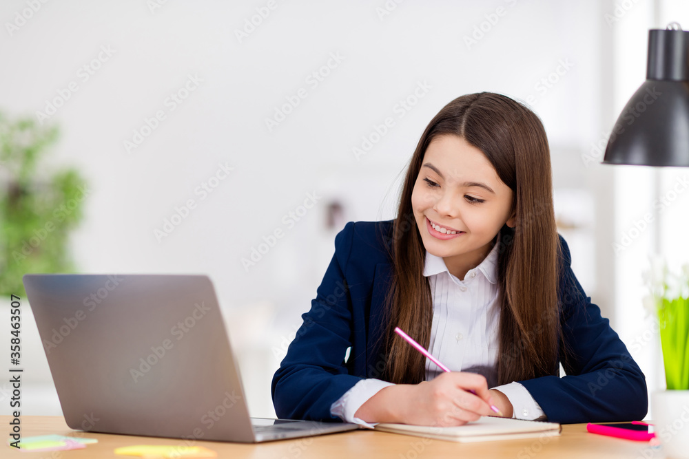 Photo of little pretty student school girl diligent student notebook table online lesson video call sit desk write notes teacher said distance quarantine study living room classroom indoors Photo of little pretty student school girl diligent student notebook table online lesson video call sit desk write notes teacher said distance quarantine study living room classroom indoors