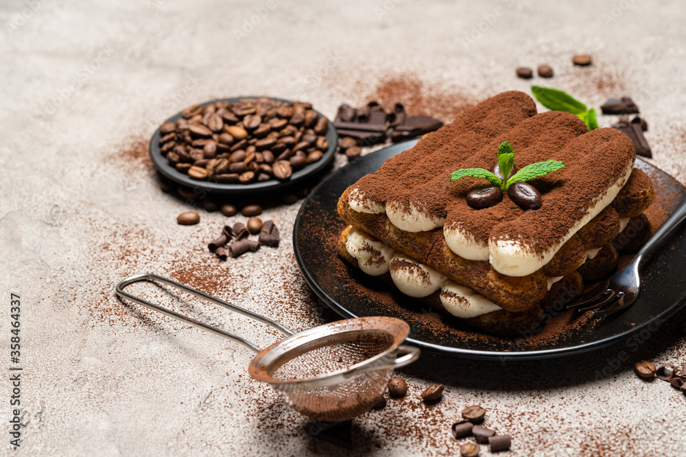 Classic tiramisu dessert on ceramic plate on concrete background Classic tiramisu dessert on ceramic plate on concrete background