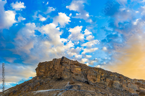 It's Edge of the rock with clody blue sky behind photo