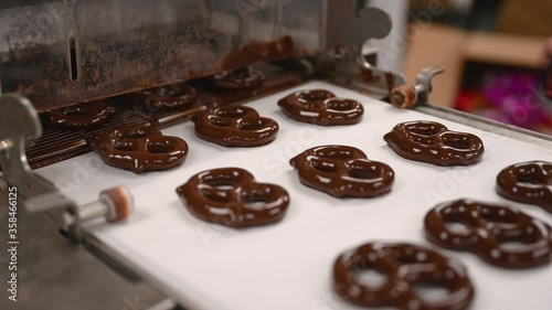 Close up of Chocolate covered pretzels coming out from the chocolate enrober photo