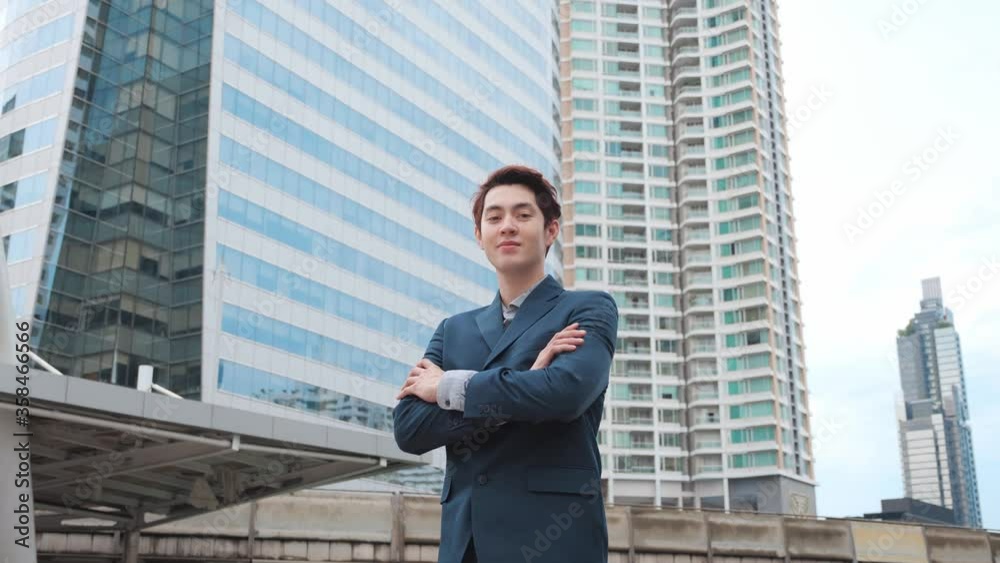 Portrait of businessman Asian mixed race in suit crossed his arms over his chest, modern glass office building background. A man looks in camera, proud and sure of himself. Portrait of businessman Asian mixed race in suit crossed his arms over his chest, modern glass office building background. A man looks in camera, proud and sure of himself.