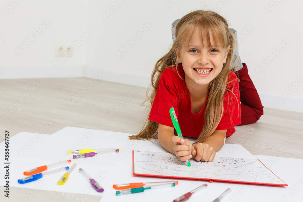 Education at home concept - Cute little girl studying with pile of books on the floor at home. Isolated over white background Education at home concept - Cute little girl studying with pile of books on the floor at home. Isolated over white background