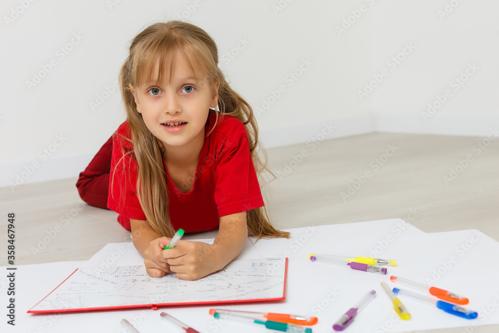 Education at home concept - Cute little girl studying with pile of books on the floor at home. Isolated over white background Education at home concept - Cute little girl studying with pile of books on the floor at home. Isolated over white background