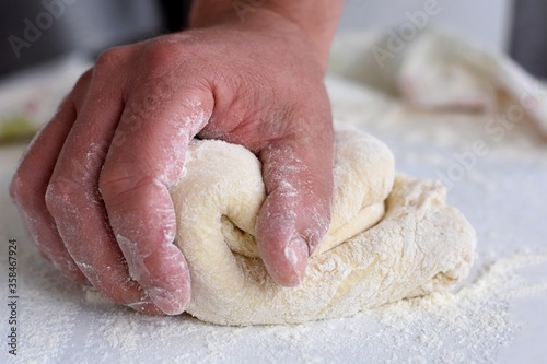 Bread making process. Closeup of man hands kneading dough. Baker cooking pastry. Culinary courses and food preparation.