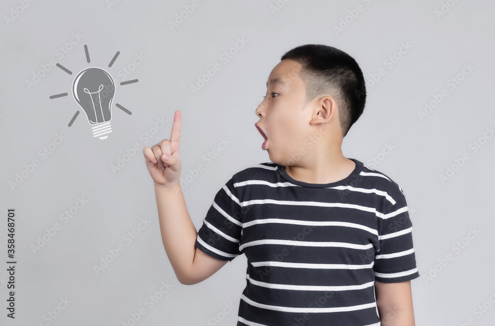 boy is showing finger while having an idea and looking at camera with an open mouth and education concept boy is showing finger while having an idea and looking at camera with an open mouth and education concept