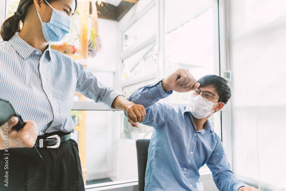 Happy office workers Smiling in face mask elbow bumping with protection of coronavirus. Happy office workers Smiling in face mask elbow bumping with protection of coronavirus.